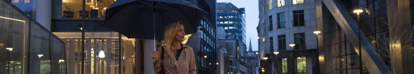woman-going-out-city-while-it-rains-min